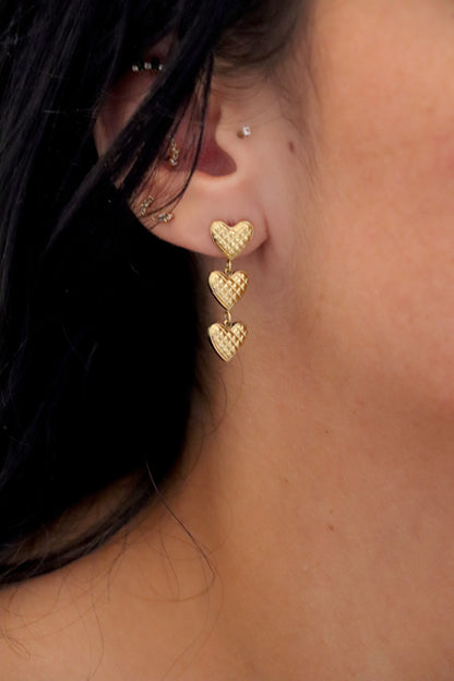 Boucle pendante dorée avec trois petits cœurs mobiles en acier inoxydable – bijou fin, féminin et tendance.