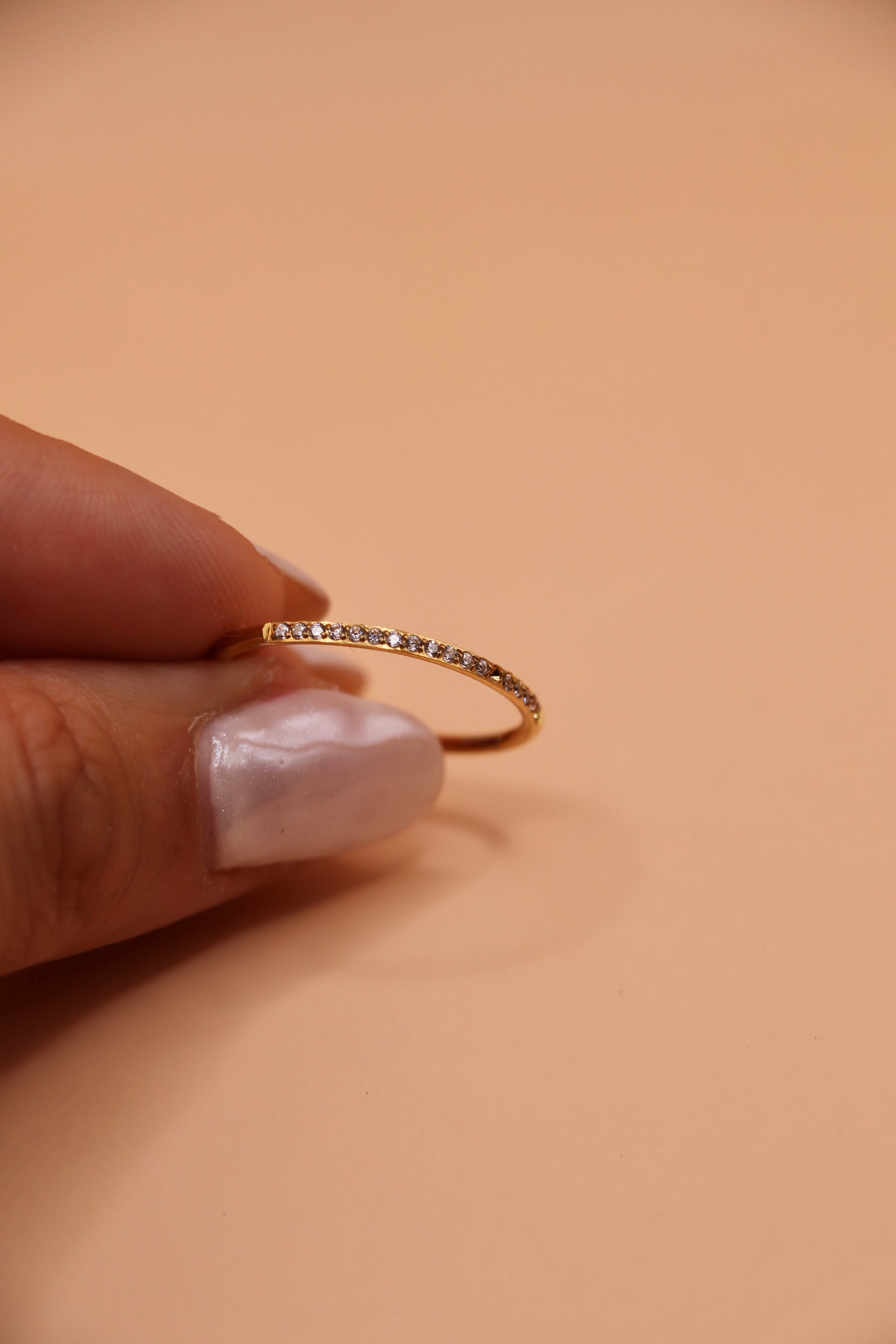 Bague fine en acier inoxydable doré sertie de petits zircons blancs – bijou minimaliste et tendance.