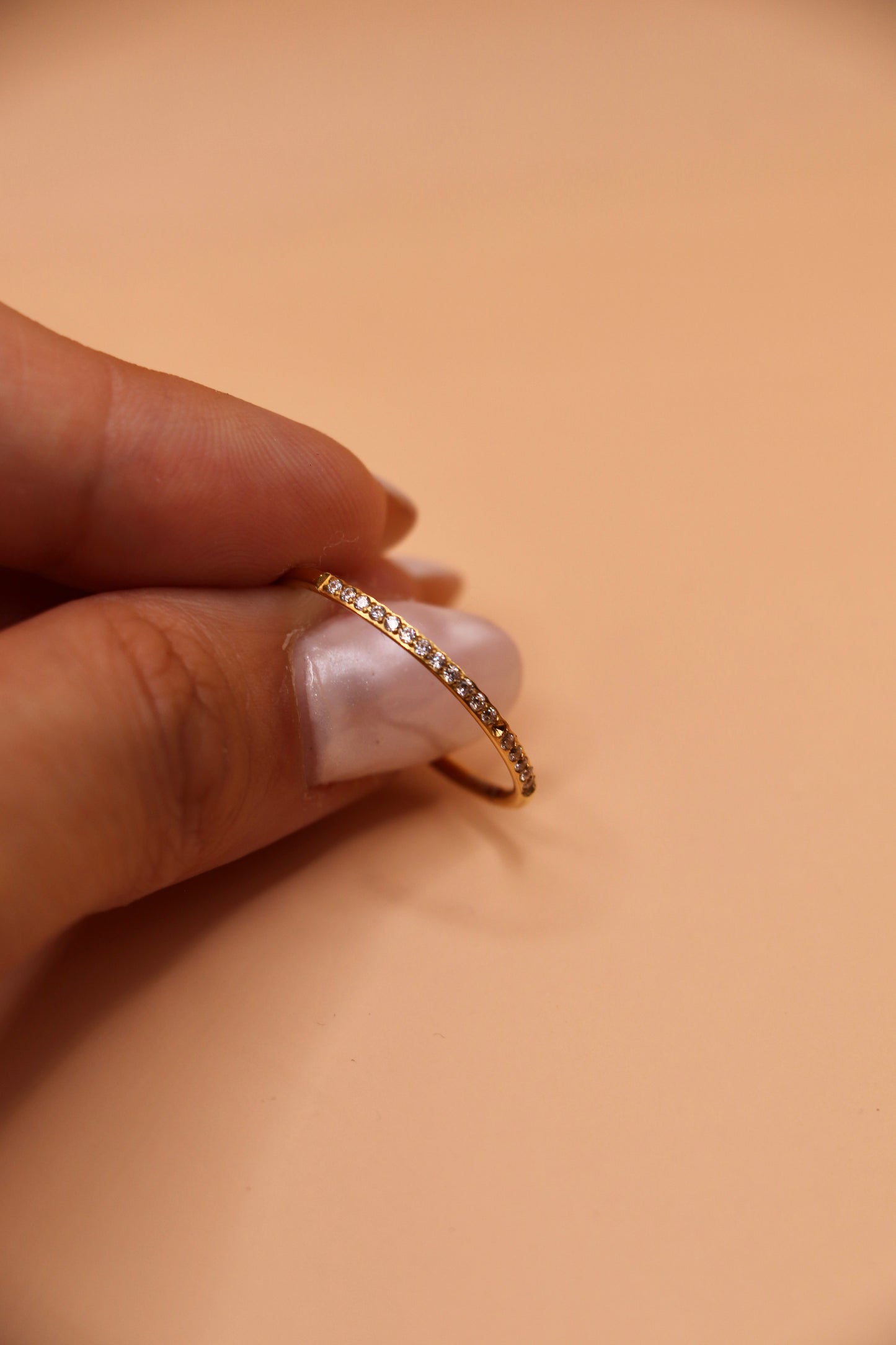 Bague fine en acier inoxydable doré sertie de petits zircons blancs – bijou minimaliste et tendance.