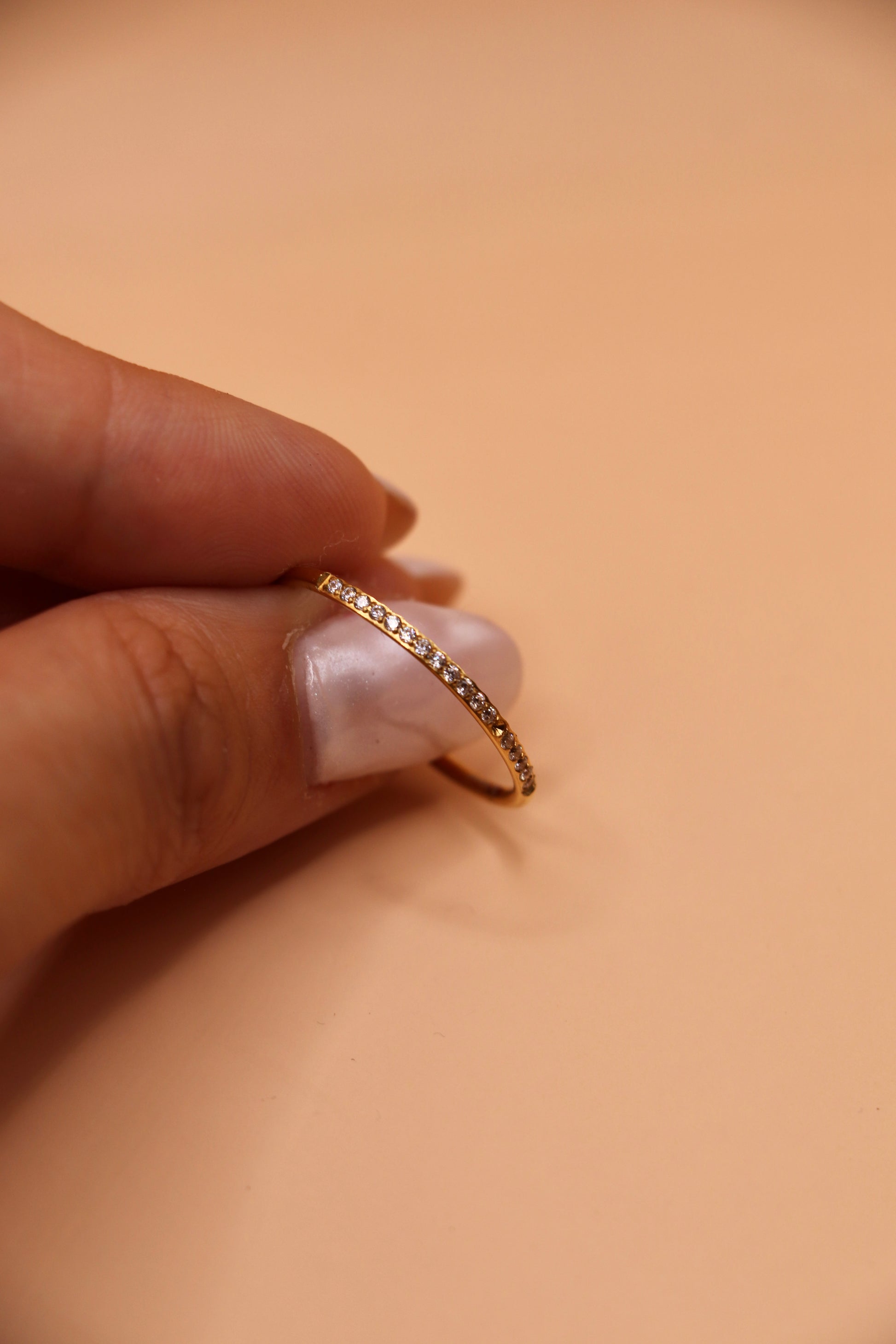 Bague fine en acier inoxydable doré sertie de petits zircons blancs – bijou minimaliste et tendance.