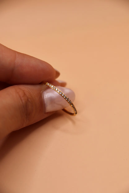 Bague fine en acier inoxydable doré sertie de petits zircons blancs – bijou minimaliste et tendance.