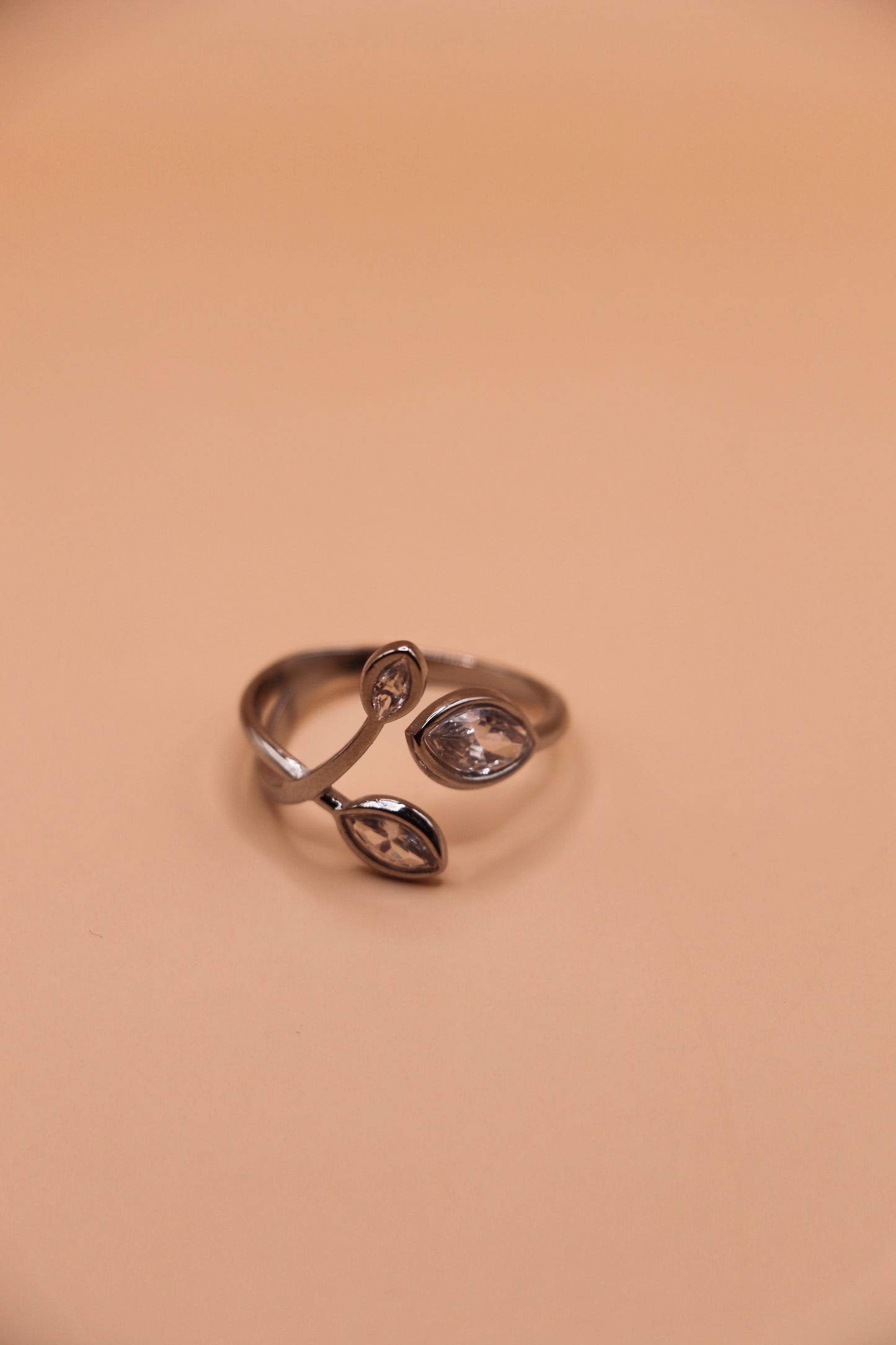 Bague ouverte argentée en acier inoxydable avec branches serties de zircons – bijou ajustable au style végétal raffiné.