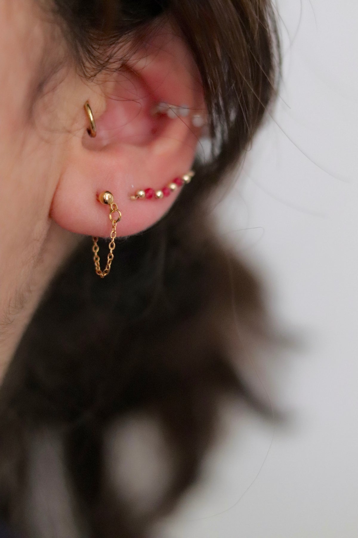 Boucle d'oreilles en or laminé 14k avec sa chaine doré qui enlace le lobe