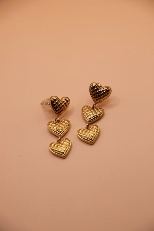 Boucle pendante dorée avec trois petits cœurs mobiles en acier inoxydable – bijou fin, féminin et tendance.