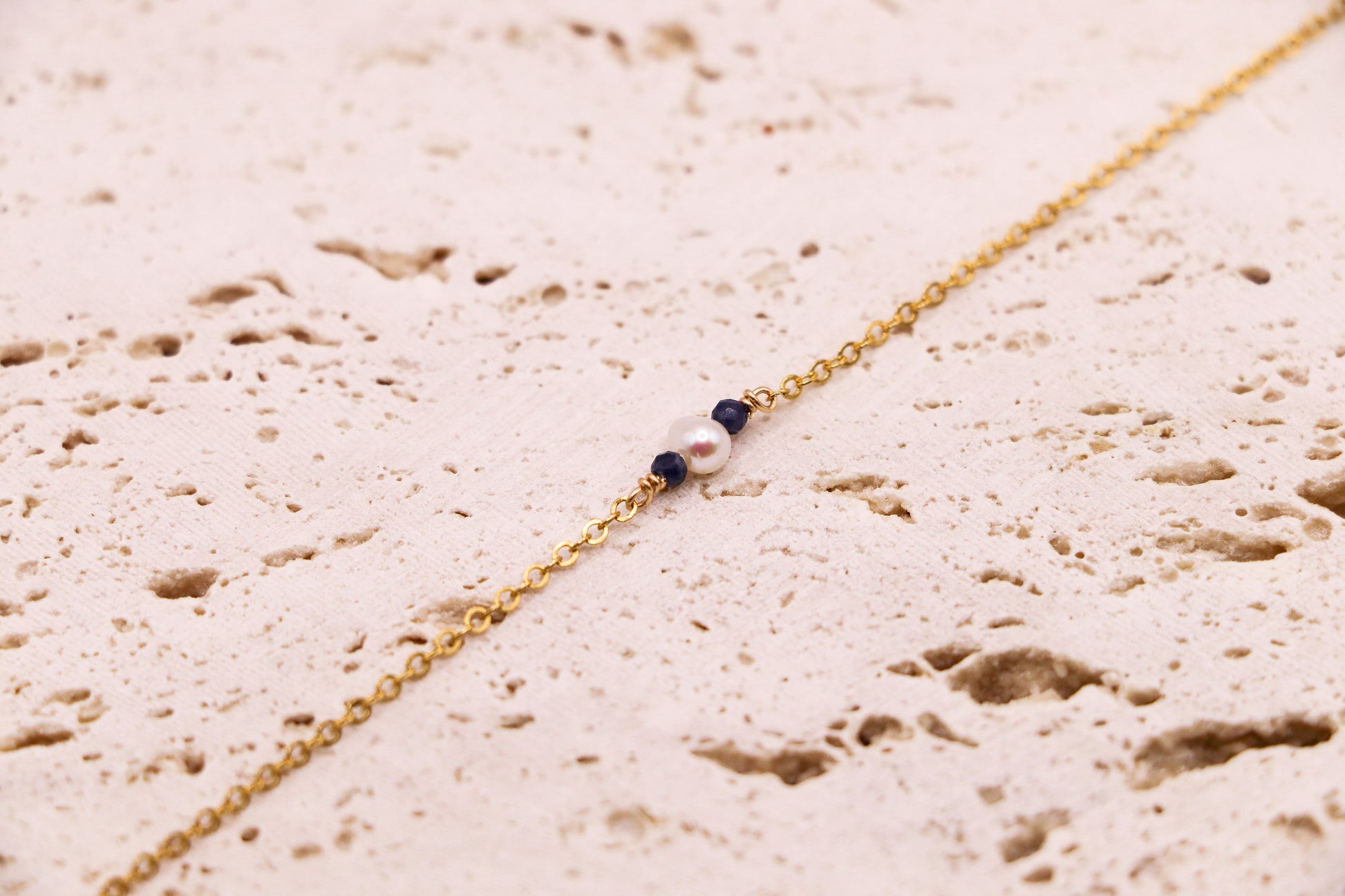Bracelet délicat en or laminé avec perle d’eau douce et deux perles de saphir, bijou fait main élégant et raffiné.