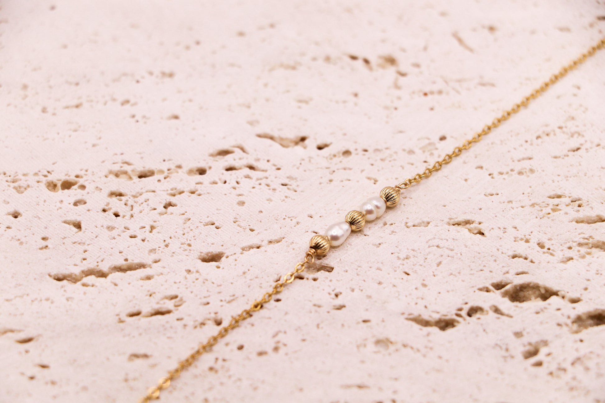 Bracelet en or laminé 14K avec deux perles d’eau douce naturelles encadrées de perles dorées striées – bijou fin, lumineux, fait main en France.