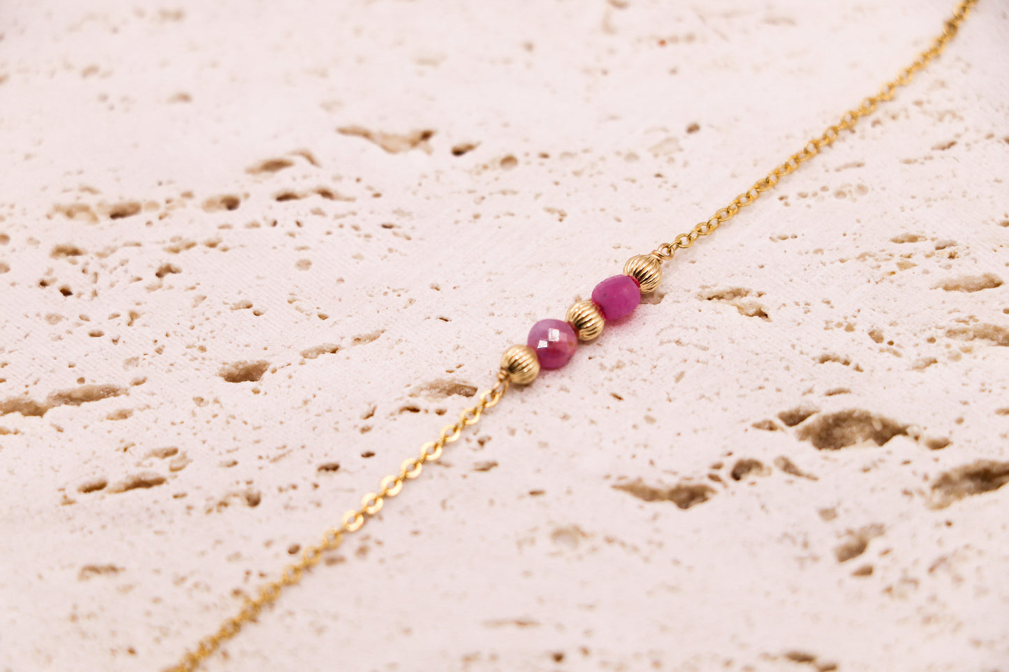 Bracelet en or laminé avec 2 rubis facettés encadrés de perles dorées striées – bijou fin et coloré, fait main en France.