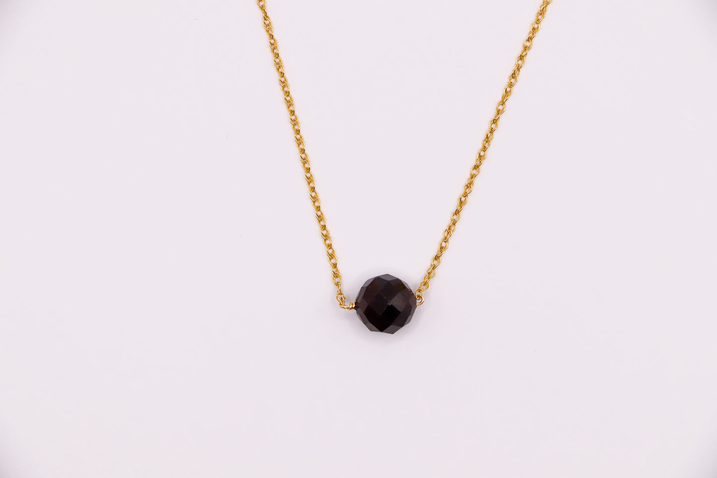 Collier Sélène en gold-filled, orné d’une pierre grenat, symbole de passion et d’énergie, parfait pour sublimer vos tenues.